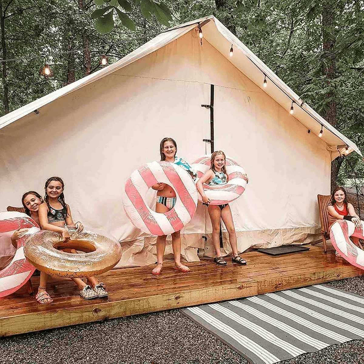 alpha wall tent set up on a platform with kids thoroughly enjoying