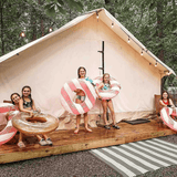 alpha wall tent set up on a platform with kids thoroughly enjoying