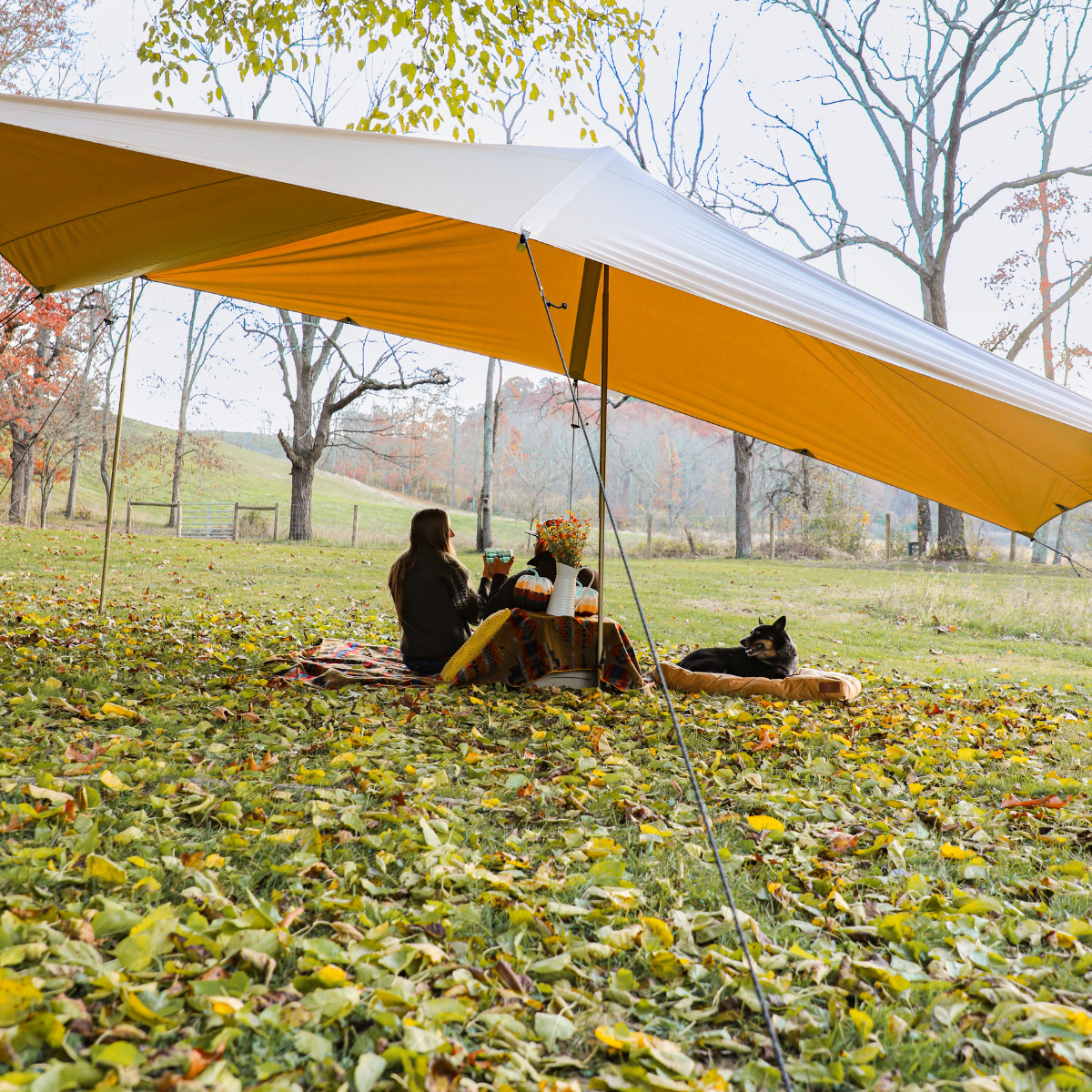 A couple is having drinks under the sunshade tarp.