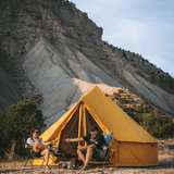 10 Regatta Bell Tent Tuscan Sun in front of mountain with a couple sitting in front