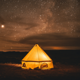 Beige 10' Regatta Bell Tent with lights inside glowing under the starry sky at night