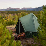 Regatta bell tent forest green placed in a forest with fairy lights