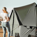 Regatta bell tent forest green color placed in the sunlight with a girl standing in front of it