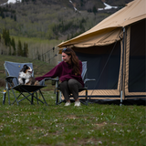 altimus bell tent placed outdoors with a woman enjoying time with her dog in front of the tent