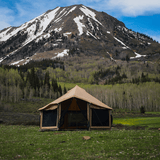 altimus bell tent set up outdoors in grassy lands in front of a mountain