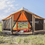 altimus bell tent set up outdoors on the grass with a dog and owner sitting inside blinds rolled up mesh closed