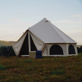 avalon bell tent placed outdoors with flaps open and mesh closed