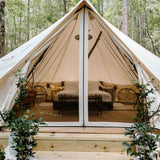 avalon bell tent set up for glamping with a bed and furniture inside it with fairy lights