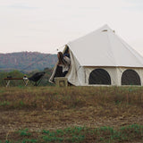 avalon bell tent set up on grassland with women coming out of it