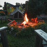 beige 10' Regatta Bell Tent set in front of house and next to bonfire