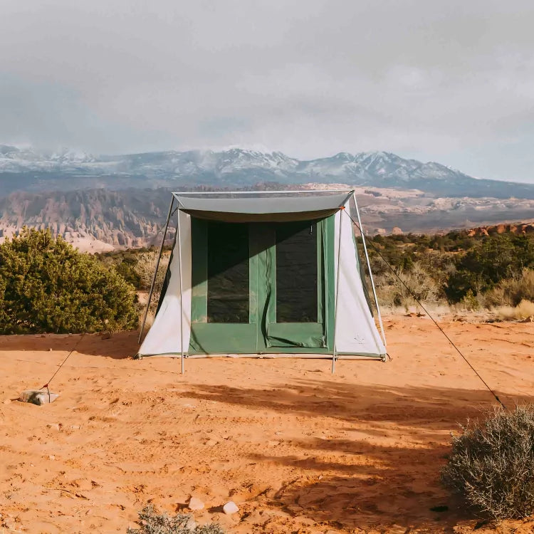 cabin tent in the desert with majestic mountains in the background
