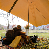 A couple is enjoying the weather under the sunshade tarp.