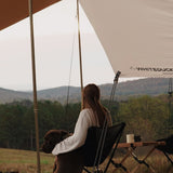 a girl sitting under the sunshade tarp with her dog enjoying the weather